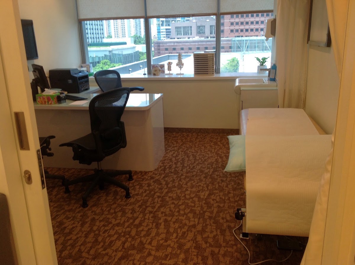 Completed clinic consultation room with desk, examination couch and city view